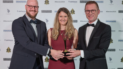 Drei Mitarbeitende der PTV Group – Fabian Appelius, Janine Stuchl und Tomasz Piernicki – präsentieren den Stevie Award 2025 bei der Preisverleihung in Lissabon.