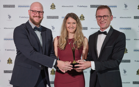 Drei Mitarbeitende der PTV Group – Fabian Appelius, Janine Stuchl und Tomasz Piernicki – präsentieren den Stevie Award 2025 bei der Preisverleihung in Lissabon.